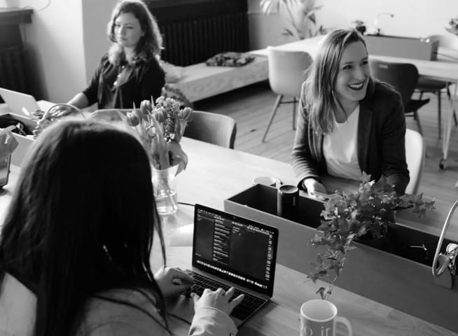 three women on their laptos and phones